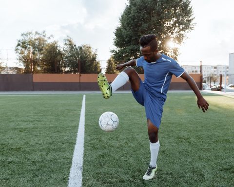 a man doing football tricks on the field