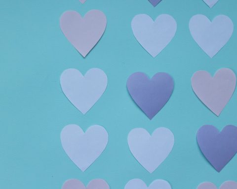 cutout paper hearts on blue background