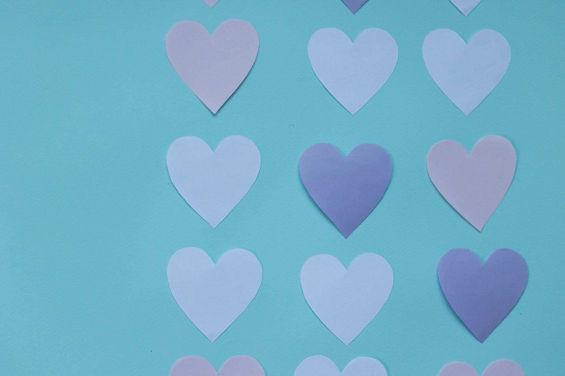 cutout paper hearts on blue background