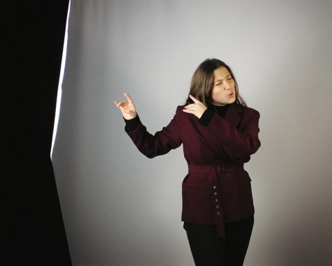 a woman standing in front of a gray background