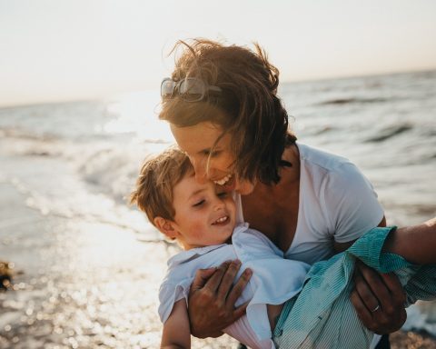 photo of mother and child beside body of water