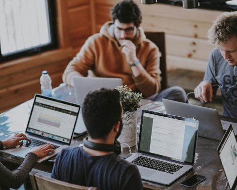 men sitting in front of their laptop computer