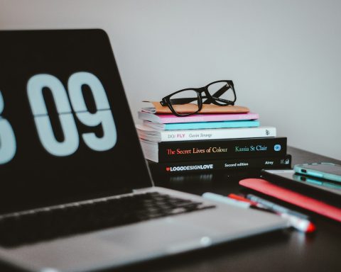 silver MacBook Pro near books