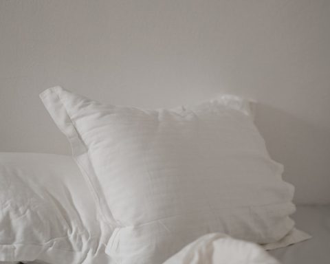 white bed pillow against white wall