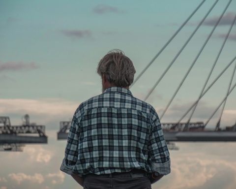 a man standing in front of a body of water