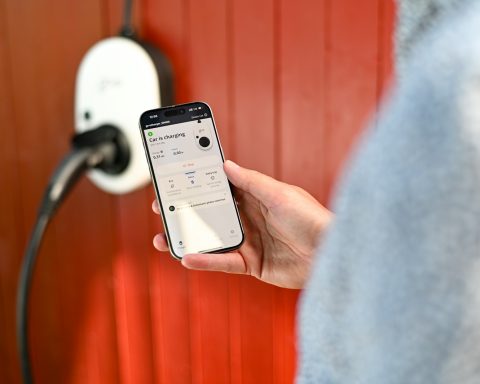 Person uses phone to control electric vehicle charger.