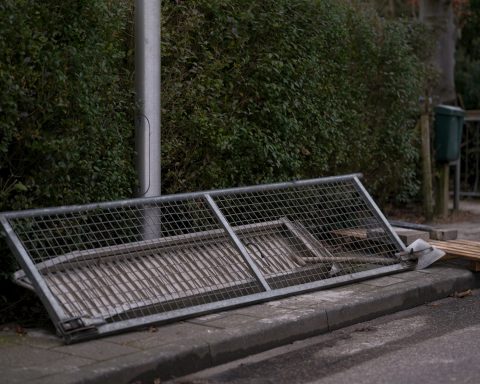 A metal bench sitting on the side of a road