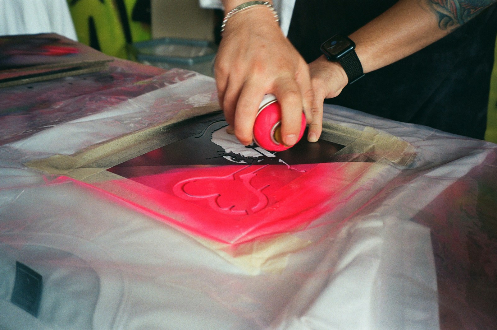 a man cutting a red piece of paper with scissors
