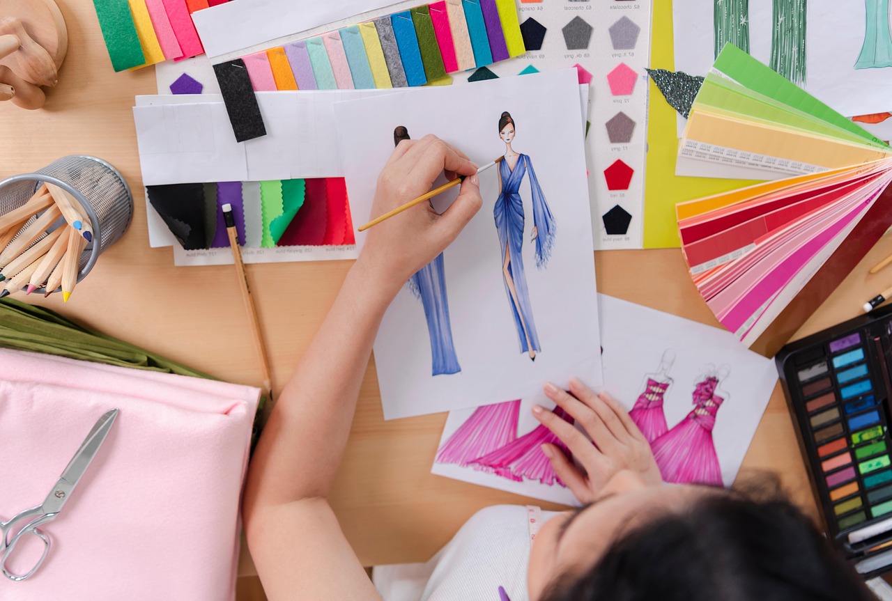 Een modeontwerper die kledingontwerpen schetst aan een werktafel