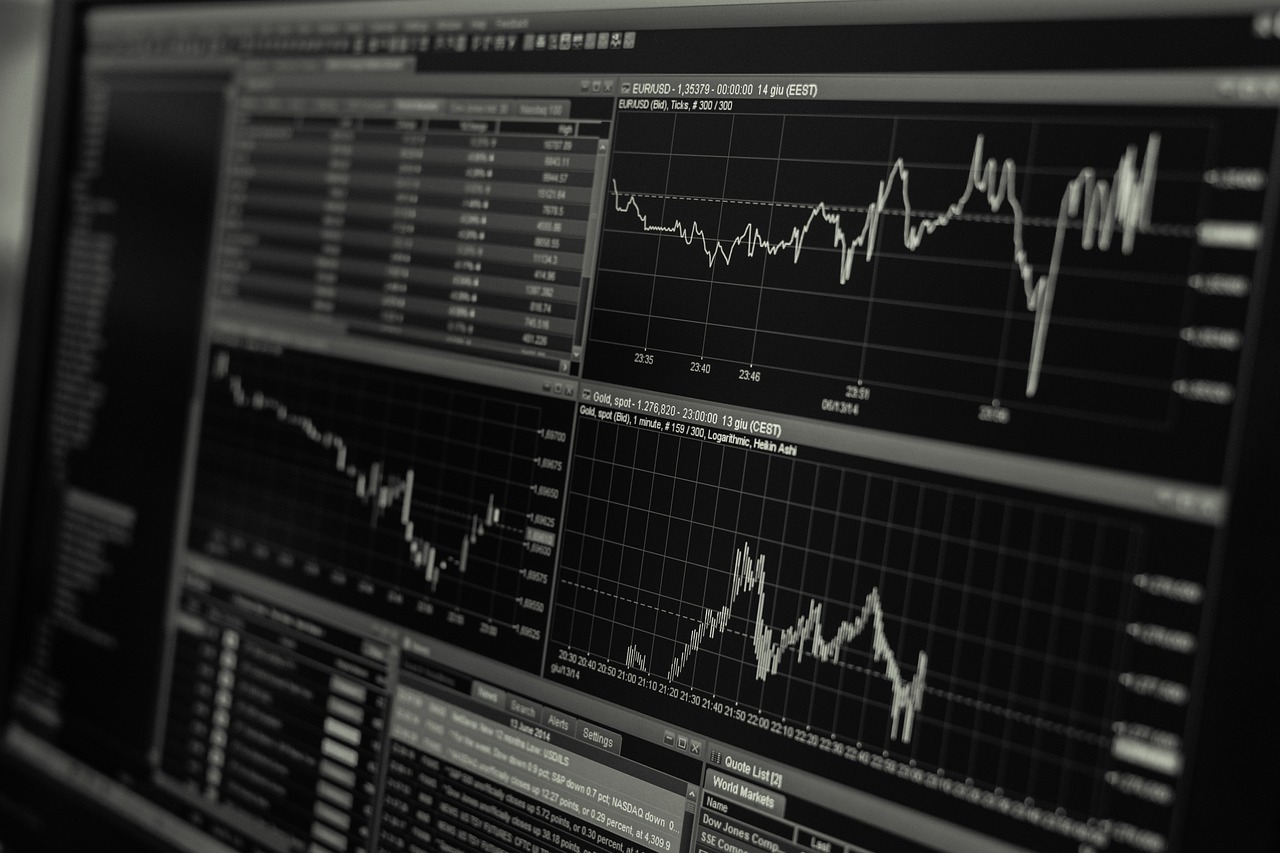 Handelsvloer van een beurs met schermen vol koersen en mensen in pak