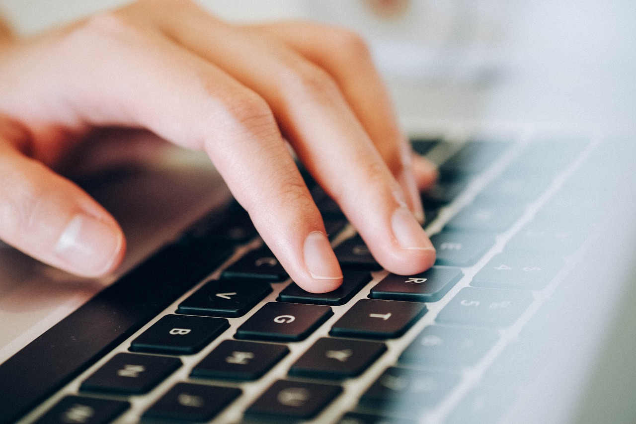 Data engineer werkt achter een laptop met code en datavisualisaties op het scherm