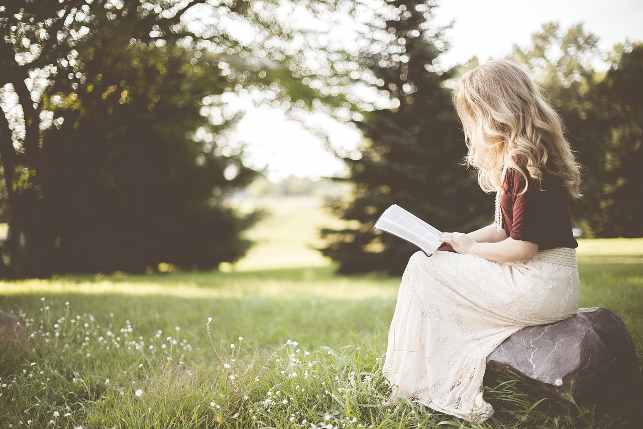 Een vrouw leest een oud Nederlands boek, verwijzend naar de rijke geschiedenis van vrouwelijke schrijfsters in Nederland