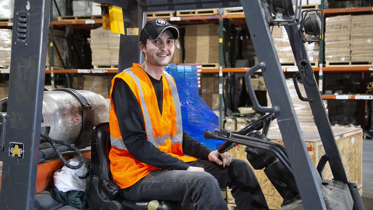 Logistiek medewerker op een heftruck in een magazijn