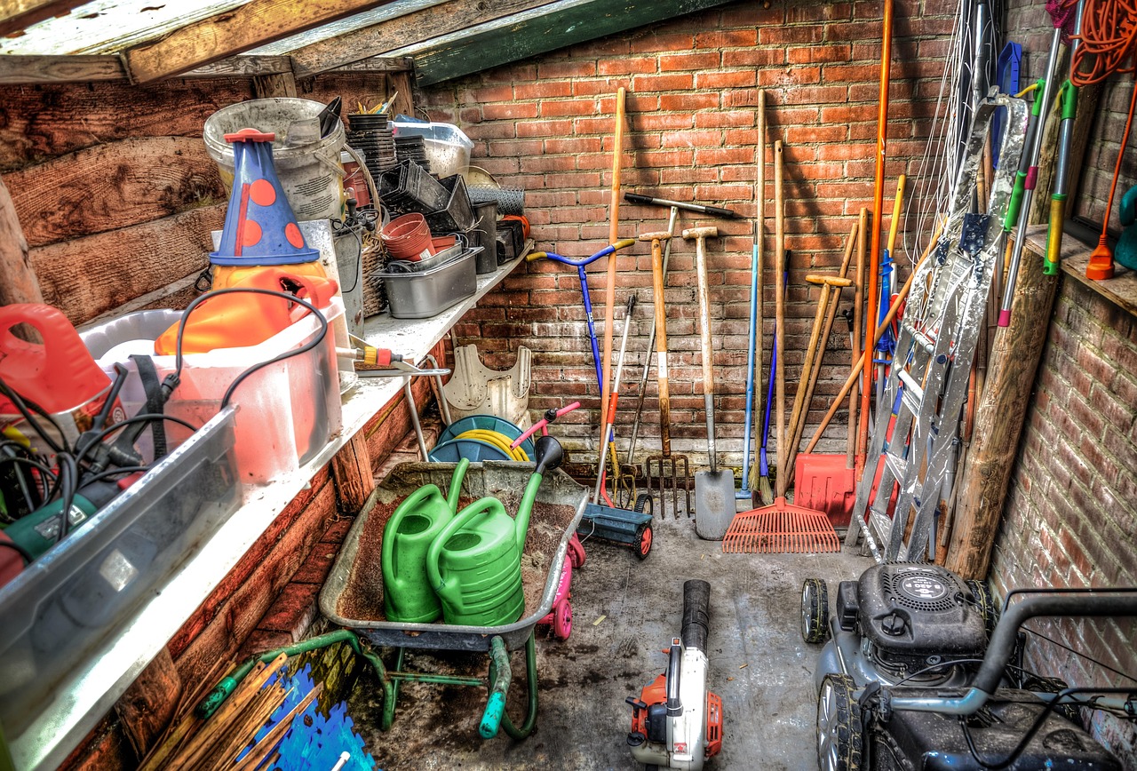 Tuingereedschap netjes opgehangen aan de muur van een schuur, klaar voor de winter