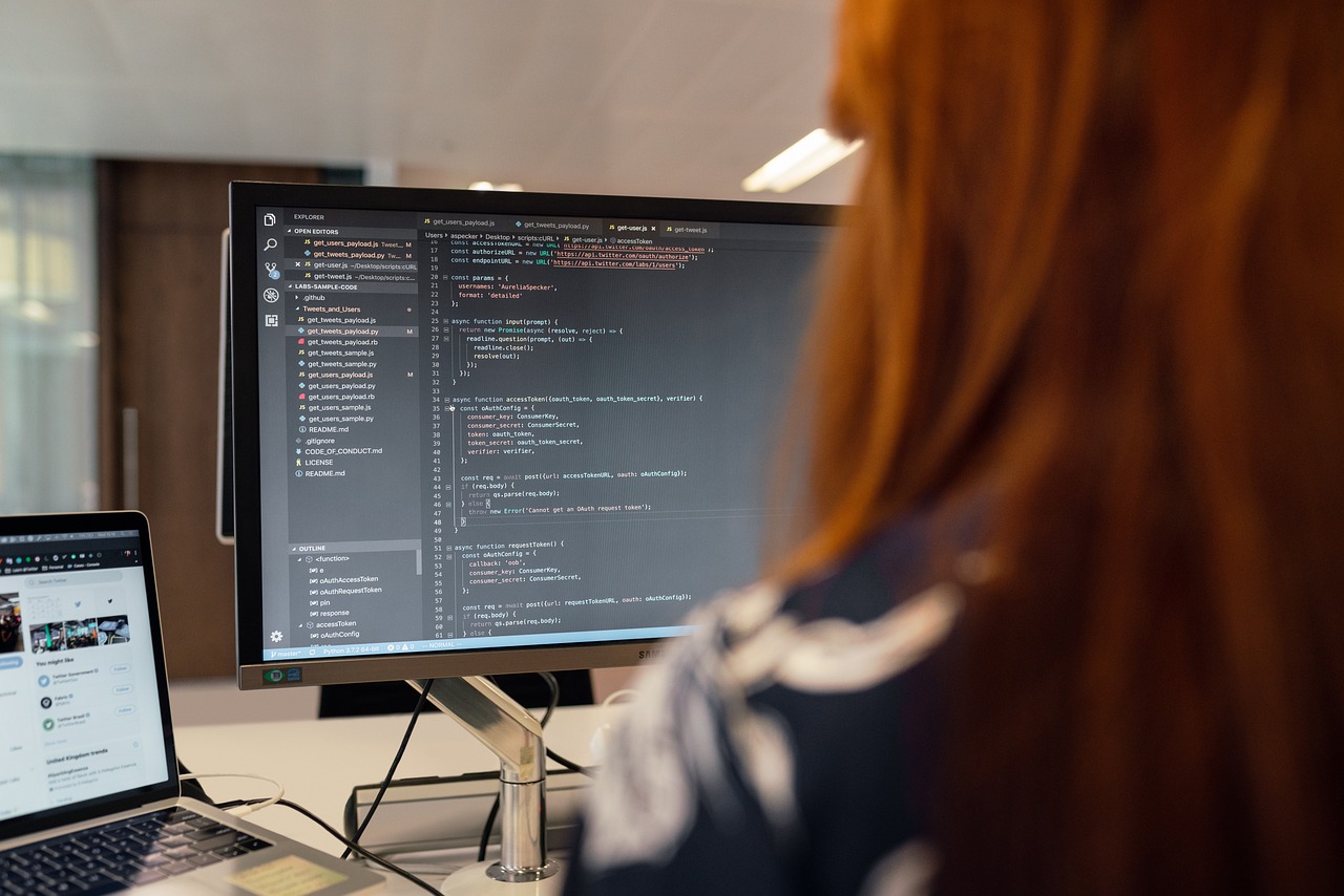 Twee developers in gesprek op kantoor, één wijst naar een scherm met code